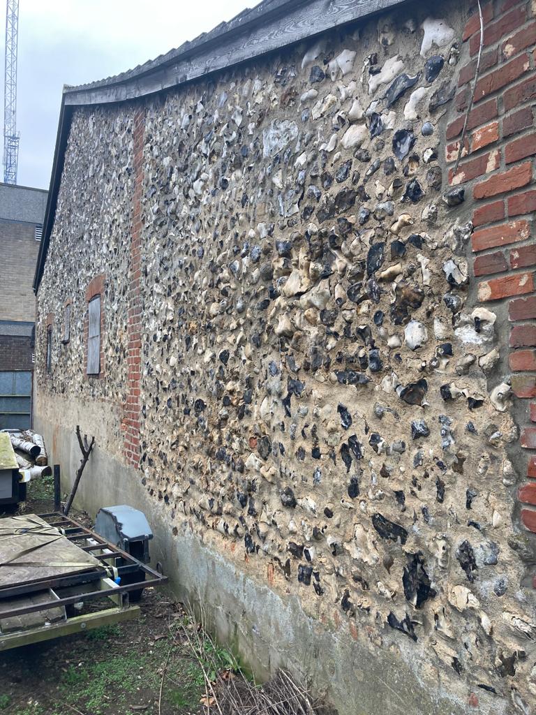 The coursed flint wall thought to be part of St Olave's eastern retaining wall [Credit: SAVE Britain